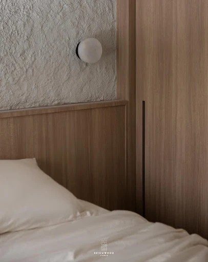 Contemporary HDB bedroom with custom wood finishes by Brickwood Studio.